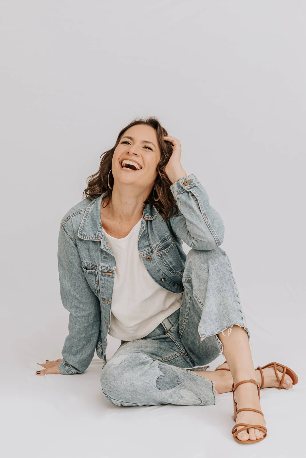 Déia sorrindo, de jeans, em ensaio fotográfico